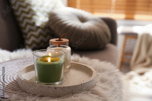 Aroma candles on grey sofa indoors. Interior design
