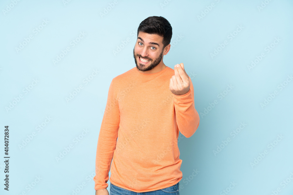 Caucasian handsome man making money gesture over isolated blue background Caucasian handsome man making money gesture over isolated blue background