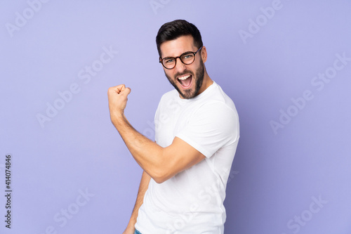 Фотография Caucasian handsome man over isolated background celebrating a victory