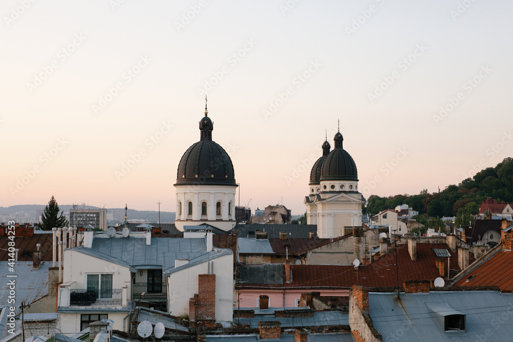 Old city buildings. View of the city from a height. Sunset over the city. Warm colors. The photo is horizontal, color.