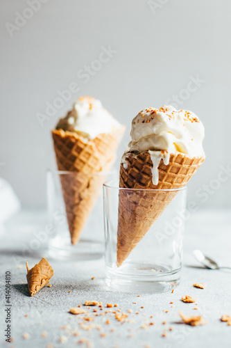 close-up of two white ice creams in waffle cups on gray background