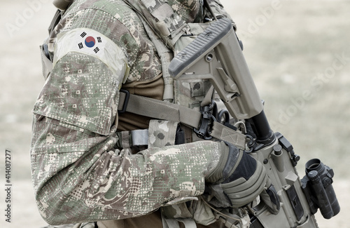 Soldier with assault rifle and flag of South Korea on military uniform. Collage.