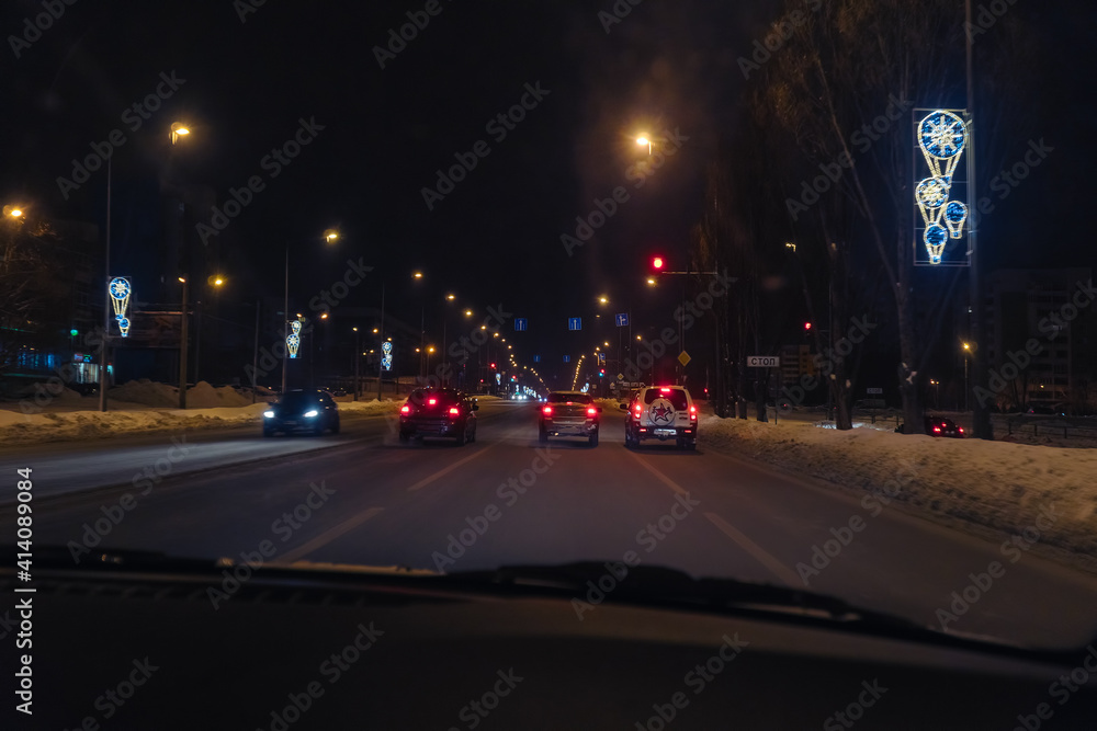 Cars in traffic in winter in the evening dark