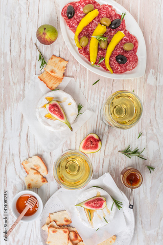 Camembert with honey, fig with antipasti and glass of white wine
