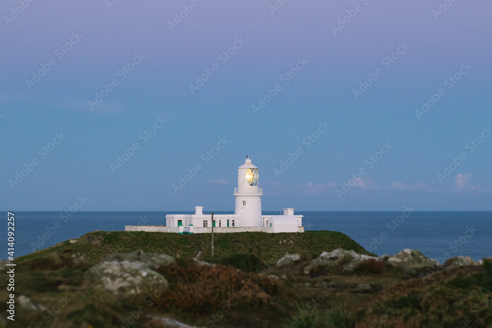 Lighthouse on the coast at sunrise.