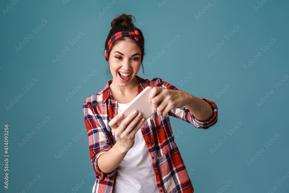 Excited beautiful brunette girl playing online game on mobile phone Excited beautiful brunette girl playing online game on mobile phone