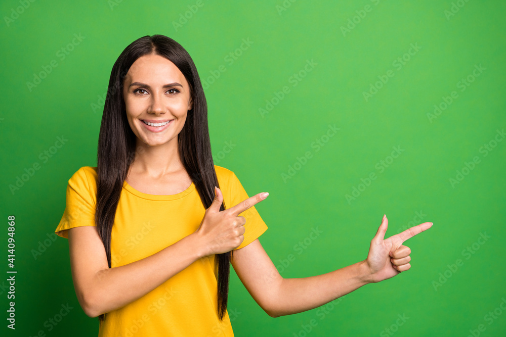 Photo of young woman happy smile point fingers empty space recommend advert promo select isolated over green color background Photo of young woman happy smile point fingers empty space recommend advert promo select isolated over green color background
