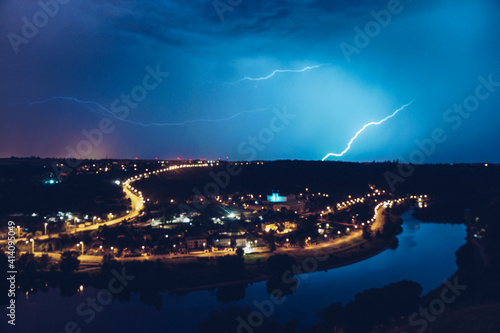 A flash of lightning over the river in the night city