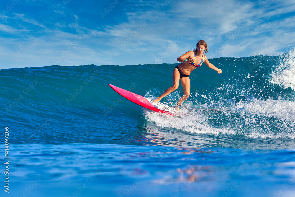 Female surfer on a blue wave at sunny day Female surfer on a blue wave at sunny day