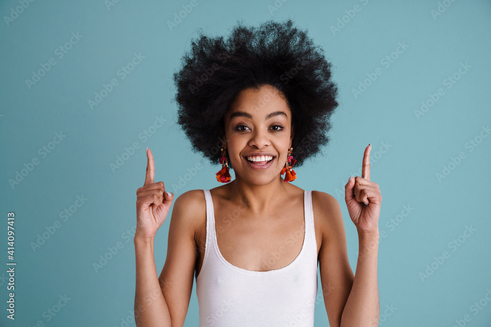 Happy african american girl smiling and pointing fingers upward