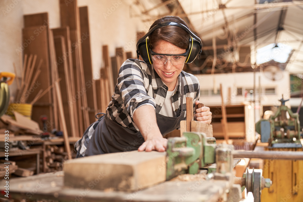 Frau in der Schreiner Ausbildung beim Holz hobeln Frau in der Schreiner Ausbildung beim Holz hobeln