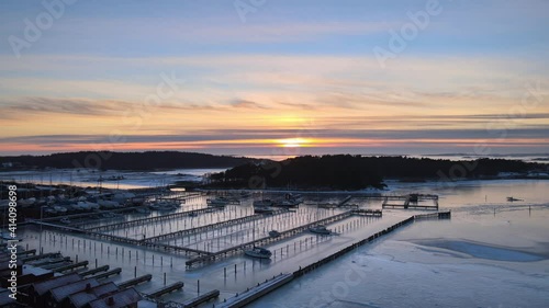 Wallpaper Mural Aerial view of small harbor at beautiful sunset one cold winter day in Hovås, Sweden. Boats stuck in ice in the marina. 4K drone footage. Torontodigital.ca