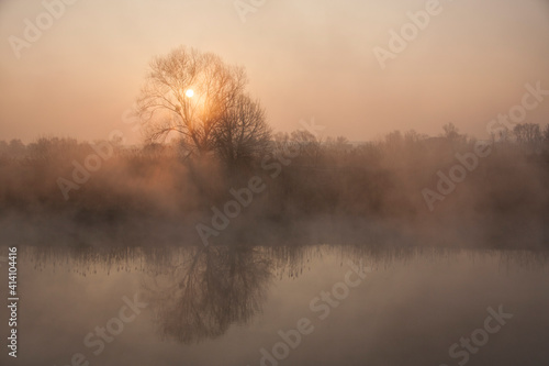 sunrise over the spring misty river
