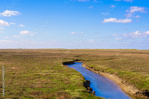 River through the salt marshes at St. Peter Ording in front of a blue sky