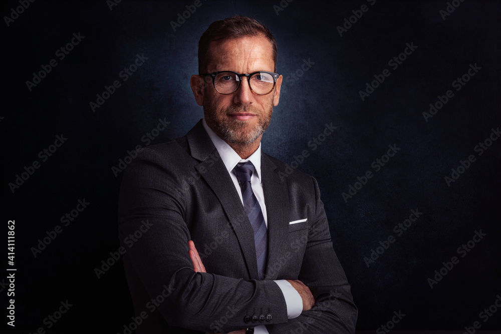 Portrait of senior businessman standing at isolated dark background Portrait of senior businessman standing at isolated dark background