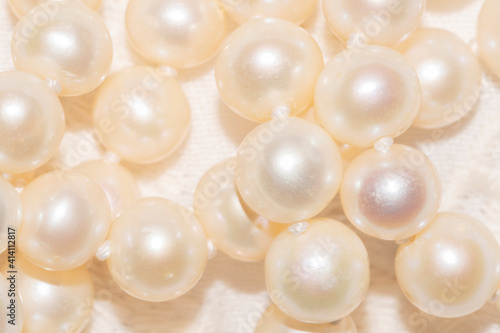 close up of white pearl necklace on an ivory fabric