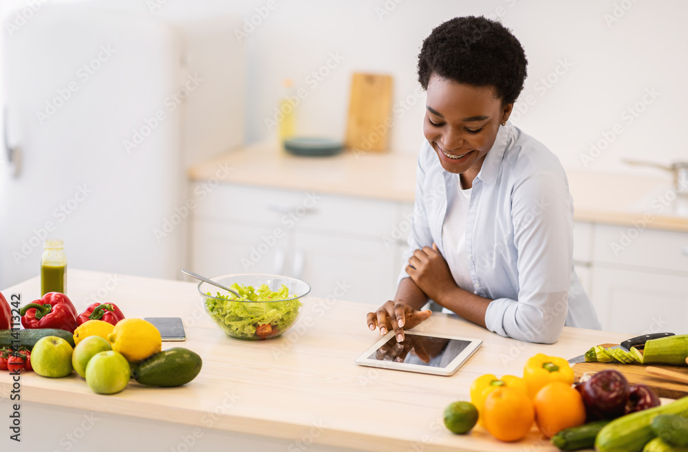 Black Woman Using Tablet Cooking Browsing Recipes Online In Kitchen Black Woman Using Tablet Cooking Browsing Recipes Online In Kitchen