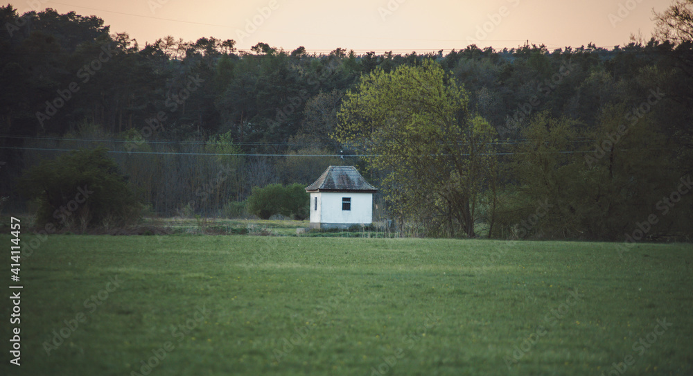 small old white house standing in the middle of a field