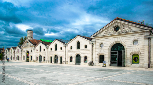 Nubes de tormenta que contrastan sobre las fachadas blancas de unos antiguos edificios industriales reconvertidos photo