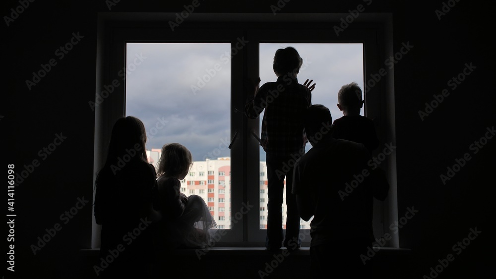 Silhouette of a large family on the background of a window in a new apartment. Quarantine concept.