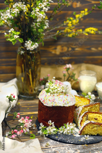 Easter sweet dessert cake. Easter cake on a dark wooden backing, ingredients. Homemade baking. The decor is apple-tree flowers. Spring concept. Copy space at the top.