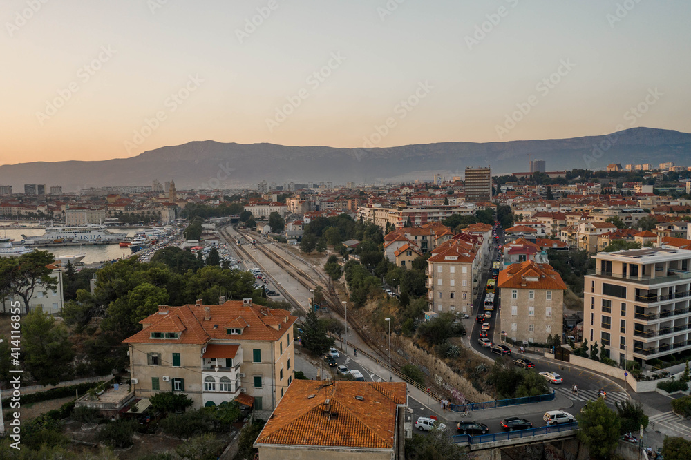 Split, Croatia - Aug 13, 2020: Aerial drone shot of railway near ferry port in sunset hour