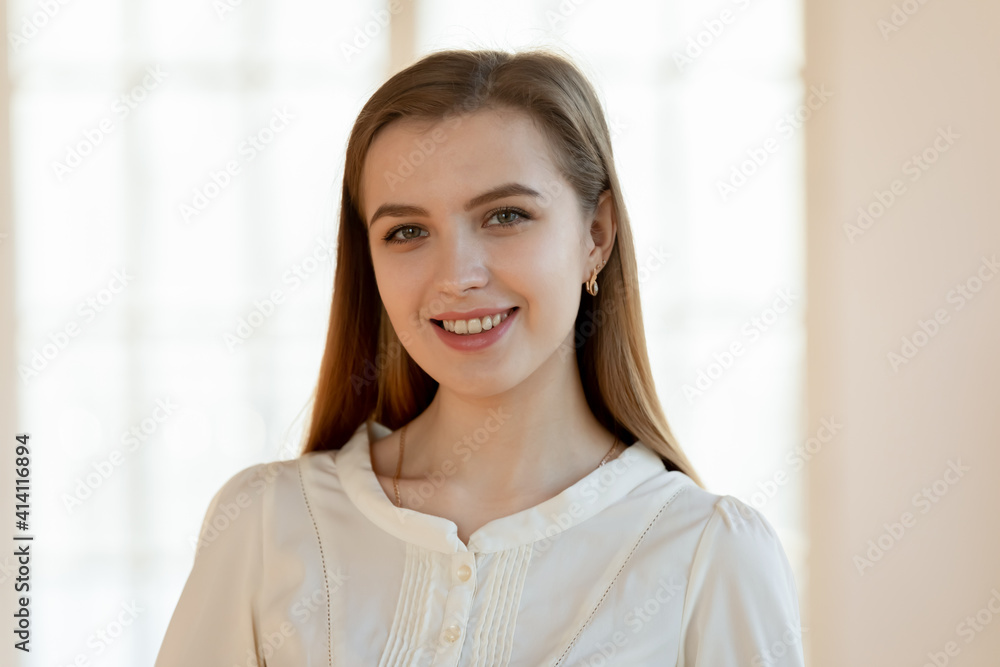 Head shot portrait of smiling attractive young woman. Happy millennial patient satisfied with provided medical services in clinic. Beautiful joyful businesswoman standing in office, looking at camera. Head shot portrait of smiling attractive young woman. Happy millennial patient satisfied with provided medical services in clinic. Beautiful joyful businesswoman standing in office, looking at camera.