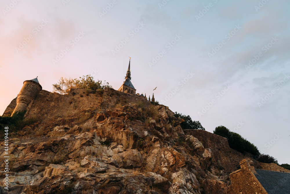 Fototapeta premium Mesmerizing view of Mont Saint-Michel at sunset in Normandy, France.