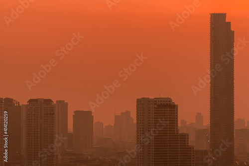 Air pollution. Smog and fine dust of pm2.5 covered city in the morning with red sunrise sky. Cityscape with polluted air. Dirty environment. Urban toxic dust. Unhealthy air. Urban unhealthy living.