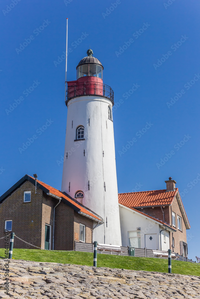 Historic white lighthouse on top of the dike in Urk, Netherlands