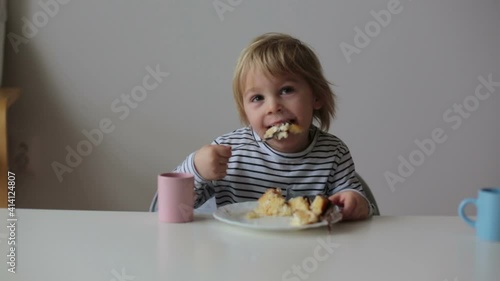 Wallpaper Mural Cute toddler child, eating piece of cake and drinking juice at home Torontodigital.ca