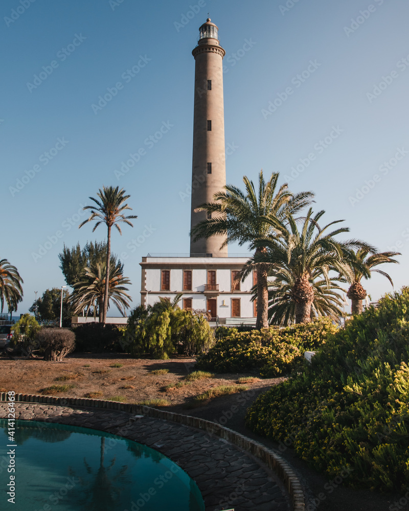 Views of a beautiful sunset over the Maspalomas lighthouse and a pool