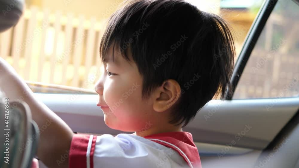 4K Asian kindergarten child boy playing with happy face in car in morning. Concept of family lifestyle, transportation, back to school. 4K Asian kindergarten child boy playing with happy face in car in morning. Concept of family lifestyle, transportation, back to school.