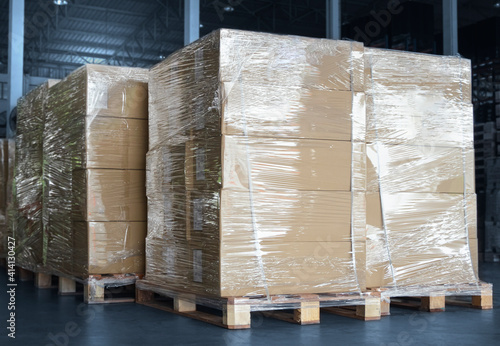 Foto Stacked of Packaging Boxes Wrapped Plastic Film on Pallets in Storage Warehouse
