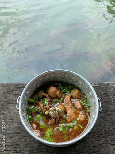 focus on Thai pork noodle known as Boat noodles or kuaitiao ruea served on Thai traditional bowl photo