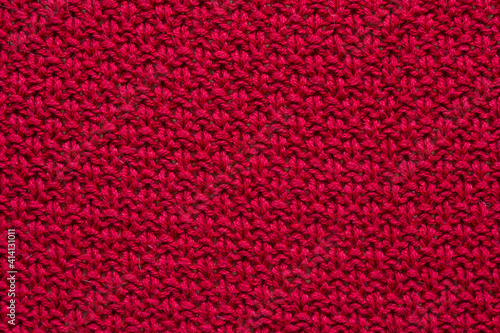 The texture of a red knitted sweater. Textured background knitting.