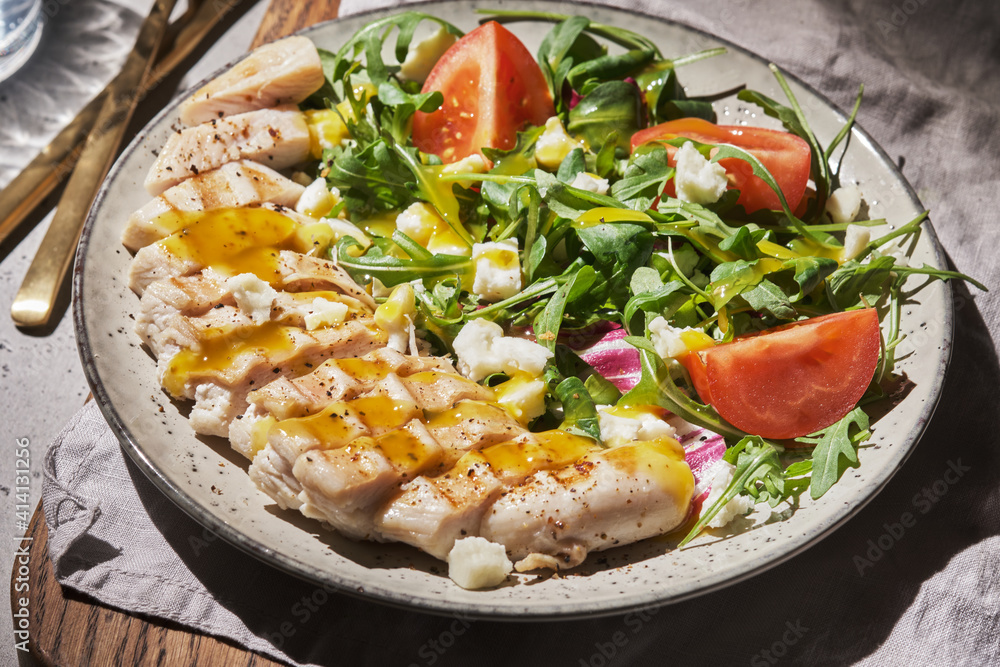 Grilled chicken breast with tomatoes and green salad with mango dressing Grilled chicken breast with tomatoes and green salad with mango dressing