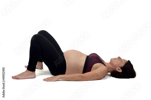 pregnant woman doing floor exercises on white backgroun,