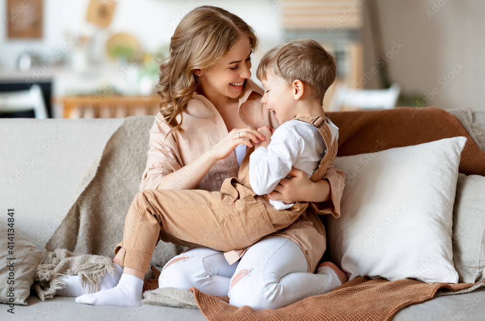 Mother and son playing on settee together Mother and son playing on settee together