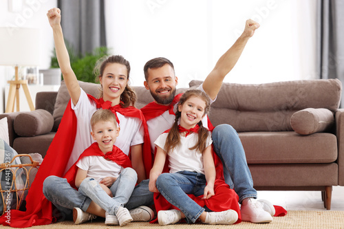 Positive family in Superhero outfits having fun together at home