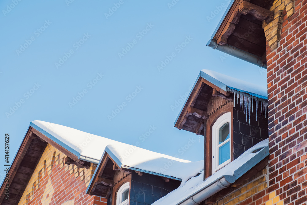 Eiszapfen an Haus und Dachrinne im Winter gefroren zu Eis