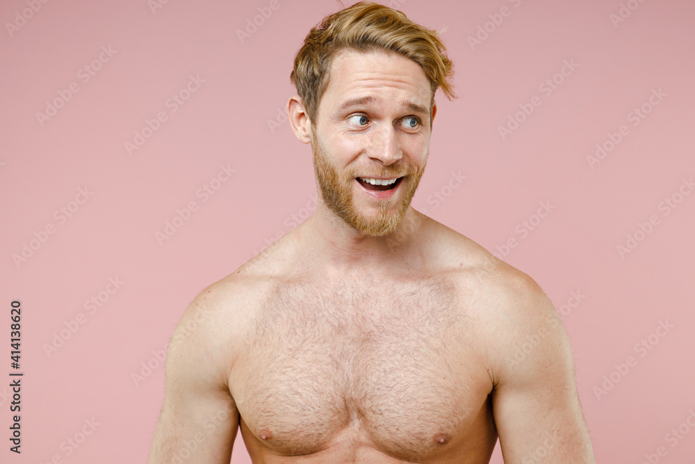 Fototapeta premium Excited bearded naked young man 20s years old perfect skin keeping mouth open looking aside isolated on pastel pink color background studio portrait. Skin care healthcare cosmetic procedures concept.