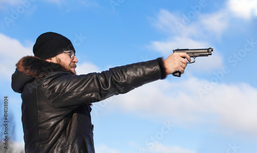 a man of European appearance in the winter forest shoots from an air pistol