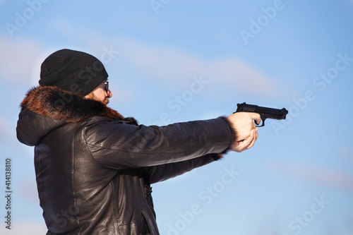 a man of European appearance in the winter forest shoots from an air pistol