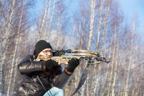 Foto a man of European appearance in the winter forest shoots from a sports crossbow