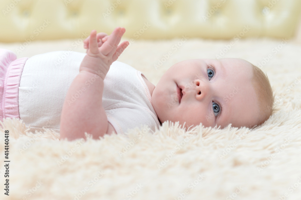 little baby girl lying on fluffy blanket and looking at the camera little baby girl lying on fluffy blanket and looking at the camera