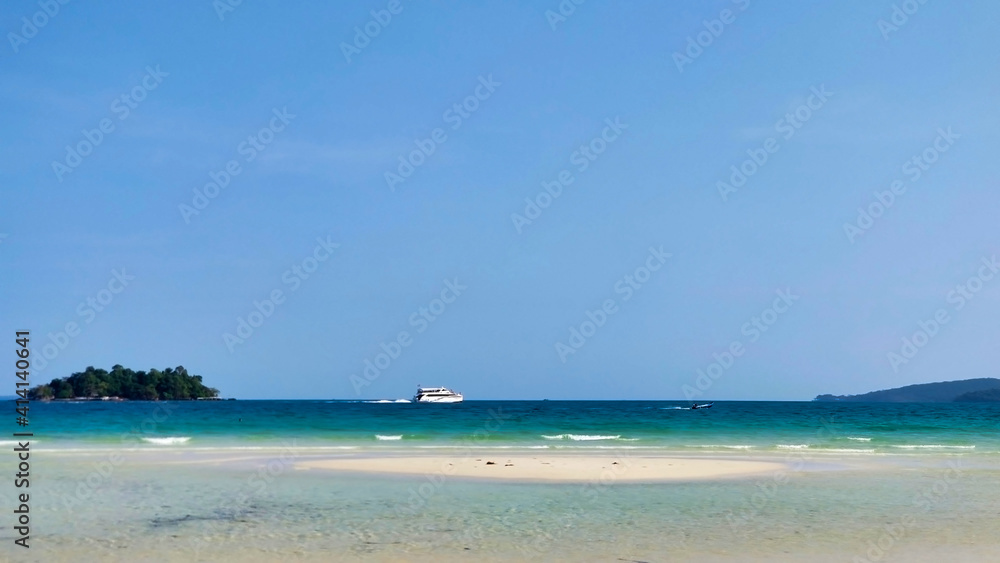 An empty beach with white sand and waves. Islands and boats in the distance. 4K Beach. Koh Rong island.  Cambodia. South-East Asia