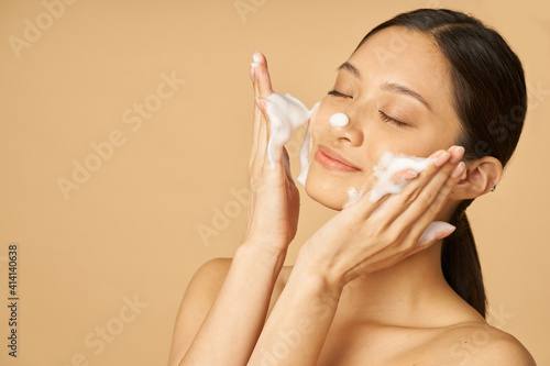 Cuadro en lienzo Beauty portrait of happy young woman smiling with eyes closed while applying gen
