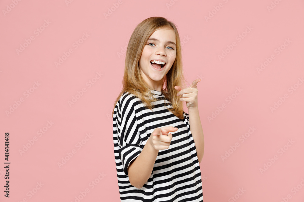 Little blonde leader happy kid girl 12-13 years old in striped oversized t-shirt point index finger camera on you isolated on pink background children studio portrait. Childhood lifestyle concept. Little blonde leader happy kid girl 12-13 years old in striped oversized t-shirt point index finger camera on you isolated on pink background children studio portrait. Childhood lifestyle concept.