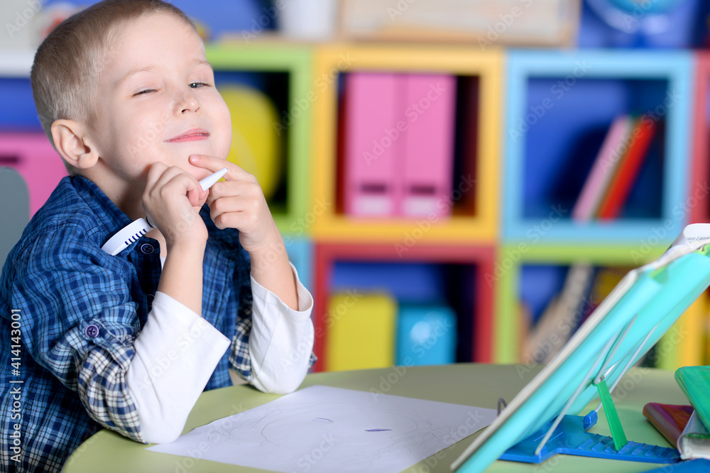 Little boy reading a book at the table Little boy reading a book at the table